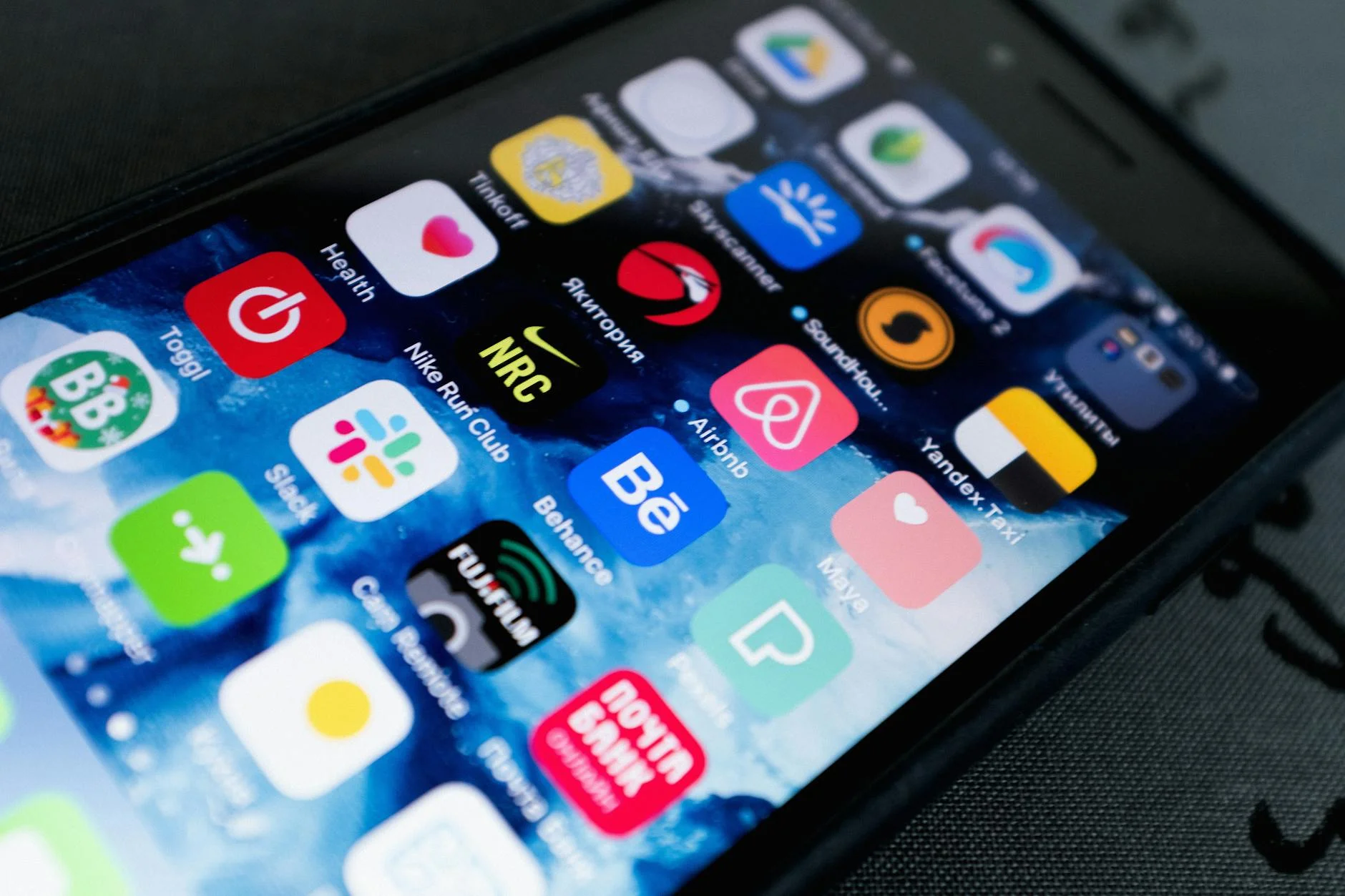 A photorealistic image of a traveler holding a smartphone, with a map showing eco-friendly routes and sustainable landmarks, surrounded by lush green nature, cinematic lighting, sharp focus on the phone and map, depth of field, 8K hyper-detailed. Detailed view of smartphone displaying multiple app icons on screen, highlighting technology use. — Foto: ready made / Pexels