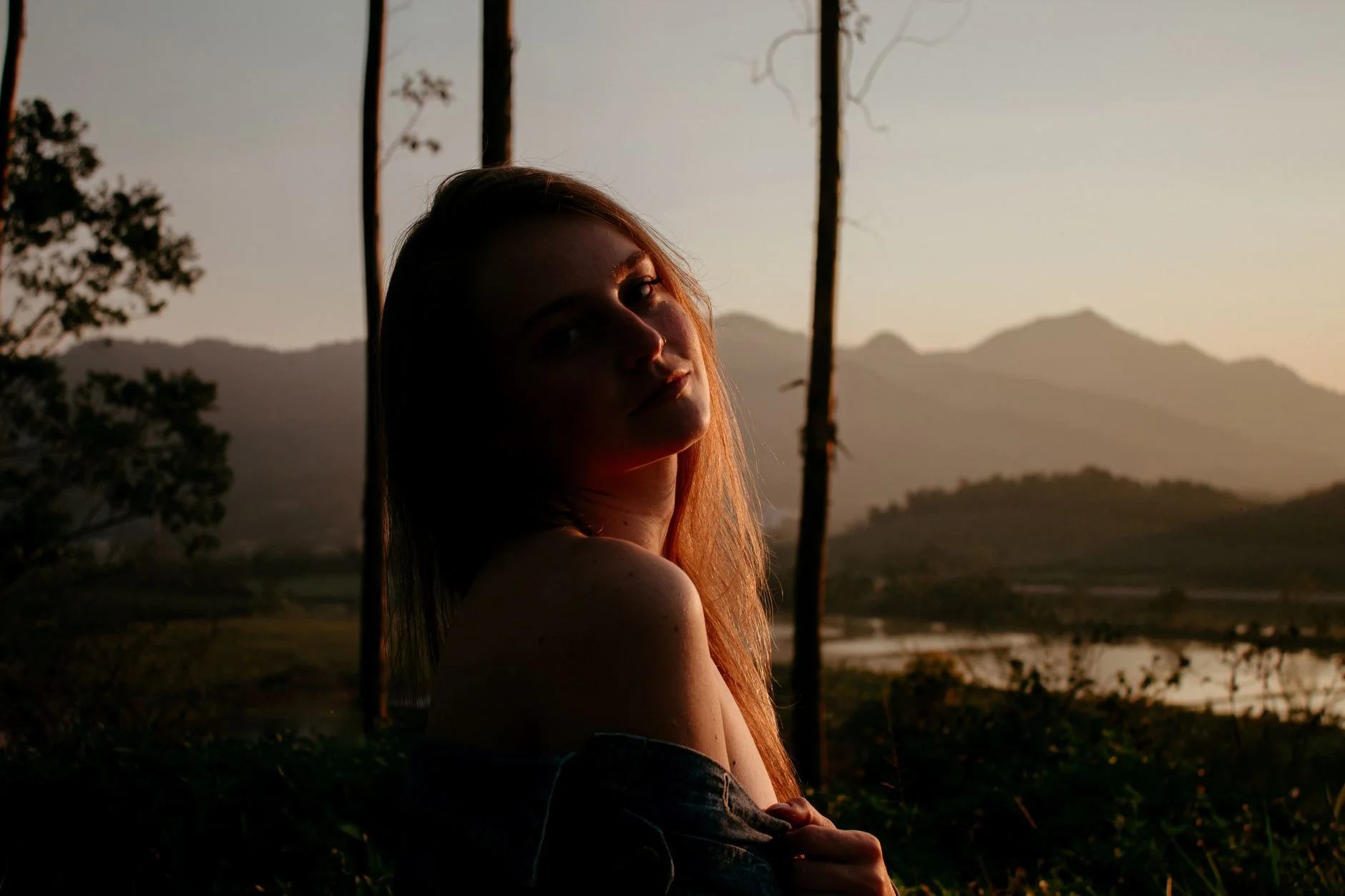 A photorealistic image of a diverse group of hikers, including people of various ages and ethnicities, smiling and interacting respectfully with a local guide in a vibrant, lush rainforest. The scene emphasizes community, sustainable travel, and cultural exchange, with clear paths and untouched nature in the background. 8K hyper-detailed, cinematic lighting, sharp focus on the group, shot on a high-end DSLR. Silhouette of a woman at sunset with scenic mountain backdrop in SC, Brazil. — Foto: Fernanda Leticia / Pexels